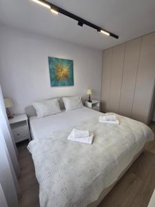 Un dormitorio con una cama grande con dos toallas encima. en Vestiq ARAD, en Arad