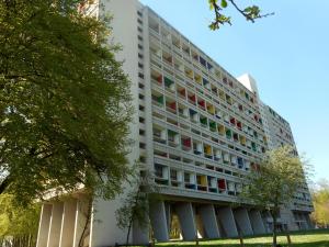a large white building with colorful windows at Le Duplex du Corbusier - Briey in Mance