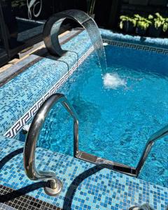 a pool with a water fountain in a swimming pool at Diamond Hotel in Chişinău +1 photo