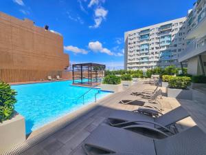 a swimming pool with lounge chairs on a building at Vito Condotel in Piapi