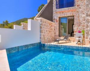 a house with a swimming pool in front of a house at Nouba Villas in Kaş