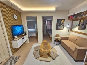 a living room with a couch and a television at Vito Condotel in Piapi