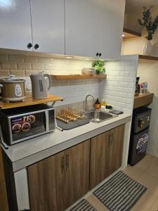 a kitchen with a sink and a microwave on a counter at Vito Condotel in Piapi