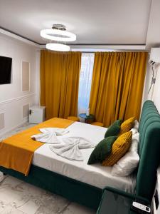a bedroom with a large bed with yellow curtains at studio lipscani Old Town Center in Bucharest