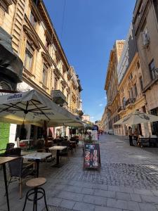 an empty street with tables and umbrellas in a city at studio lipscani Old Town Center in Bucharest