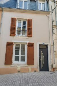 a white house with a black door and windows at Maison cosy centre-ville 5 chambres in Le Mans