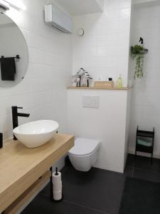 a white bathroom with a sink and a toilet at Zee en Zicht in De Panne +26 photos