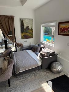 a bedroom with a bed with a couch and a window at Casa de Leon Lakeview Guesthouse in Mississauga +25 photos