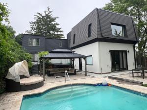 a house with a swimming pool in front of a house at Casa de Leon Lakeview Guesthouse in Mississauga