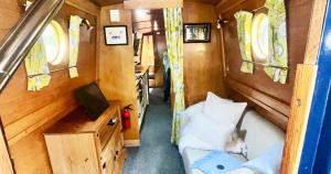 a small room with a bed and a tv at Daisy Mutler Holiday Boat Hire in Bletchley