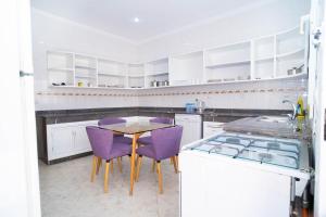 a kitchen with purple chairs and a table at Encantadora casa céntrica in Tangier
