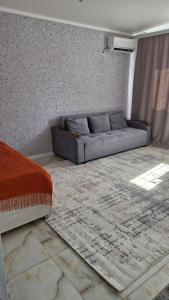 a living room with a couch and a rug at Апартаменты в центре города Балхаш in Balqash