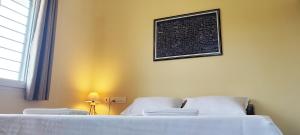 a bedroom with two beds and a chalkboard on the wall at Surya Villa Guesthouse in Auroville