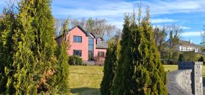 a pink house with trees in front of it at Stoneywood Haven, Galway in Clarinbridge