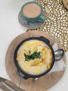 a bowl of soup on a table with a cup of coffee at Pueblito Boyacense Hotel in Duitama