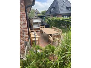 un patio con tavolo e sedie in legno di Strandnest a Sankt Peter-Ording Altre 9 foto