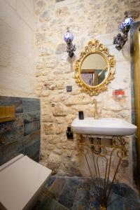 a bathroom with a sink and a mirror on a stone wall at AURA TAŞ Hotel in Urfa +54 photos