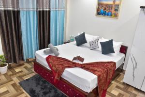 a bedroom with a bed with white sheets and pillows at Palm Tree Paradise Retreat in Kasauli