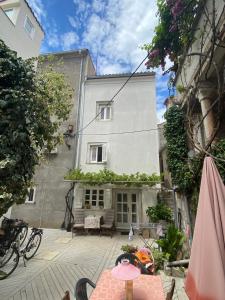 an outside view of a building with a table and an umbrella at Hidden Hideaway in Cres