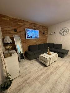 a living room with a couch and a tv at FYRED Vintage Apartman in Tiszafüred