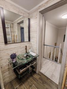 a bathroom with a glass sink and a mirror at FYRED Vintage Apartman in Tiszafüred