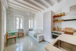 a kitchen and living room with a bed and a table at Aplotis home in Ermoupoli