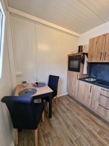 a small kitchen with a table and chairs in a room at tiny village in Echenbrunn