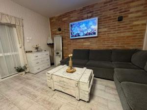 a living room with a couch and a brick wall at FYRED Vintage Apartman in Tiszafüred +27 photos