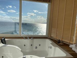 een badkamer met een bad en een groot raam bij iskele rum butik otel in Tekirdag