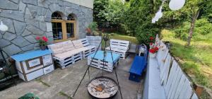 a patio with a bench and a table and a fence at Apartamenty Poza Horyzont in Korbielów