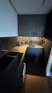 Ziogu Apartments في بالانغا: مطبخ مع حوض وطاولة عمل