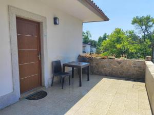 a table and a chair sitting next to a door at Quinta do Gestal - Soutelo in Vila Verde