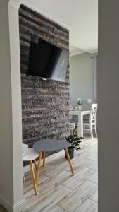 a living room with a tv on a brick wall at Apartament w Krzesznej in Krzeszna