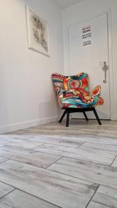 a colorful chair sitting in a room with a wall at Apartament w Krzesznej in Krzeszna +15 photos