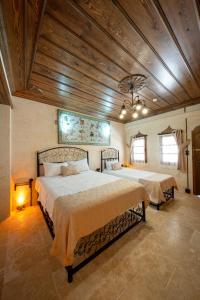 a bedroom with two beds and a wooden ceiling at AURA TAŞ Hotel in Urfa