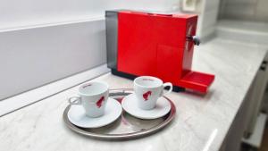 two cups on a tray on a counter with a red box at Studio VERONICA in Constanţa