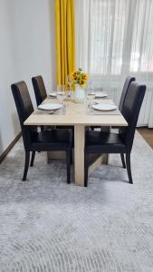 a wooden table with chairs and a vase of flowers at Studio VERONICA in Constanţa