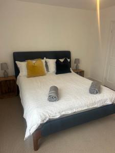 a bed with two hats and pillows on it at Spacious Town house 2 bed 2 mins 2 beach in Deal +7 photos
