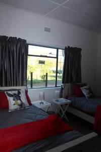 a room with two beds and a window at Papkuilsvlei Selfsorg Plaashuis in Muishondfontein