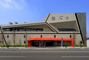 Taichung Ease Motel في Taiping: مبنى بسقف احمر مع تقليم احمر