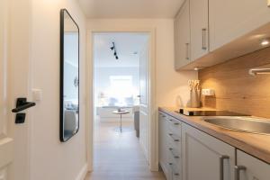 - une cuisine avec un évier et un miroir dans l'établissement Top gelegenes Apartment Wattstuuv direkt im Zentrum von St Peter Ording, à Sankt Peter-Ording