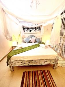 een slaapkamer met een houten bed met een hemelbed bij DADA Luxury Suites Beachfront Tropical Paradise in Malindi