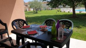 a black table with wine bottles on a patio at Casa di u sole in Santa-Maria-Poggio