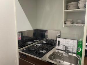 una cucina con fornelli e lavello di Yoi-Machi Heiwajima a Tokyo Altre 6 foto