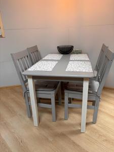 a dining room table with two chairs and a bowl on it at Helagust in Dołgie +10 photos