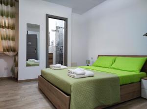 a bedroom with a green bed and a mirror at Mar&Mar in Alghero