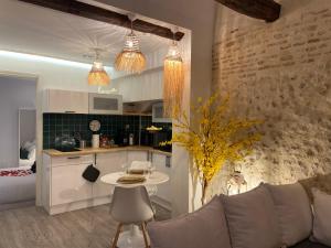 a kitchen and living room with a couch and a table at Halte Romantique in Château-Renault