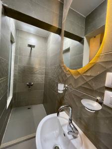 un baño con lavabo y espejo en Khufu's Pyramids Inn, en El Cairo