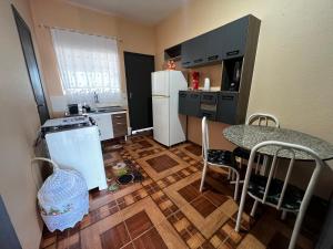 a small kitchen with a table and a refrigerator at Apto - Brasilândia do Sul - PR in Assis Chateaubriand