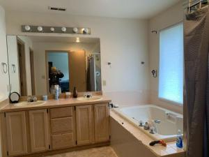 a bathroom with two sinks and a tub and a mirror at Cedar River one bedroom in a four bedroom house in Renton +29 photos